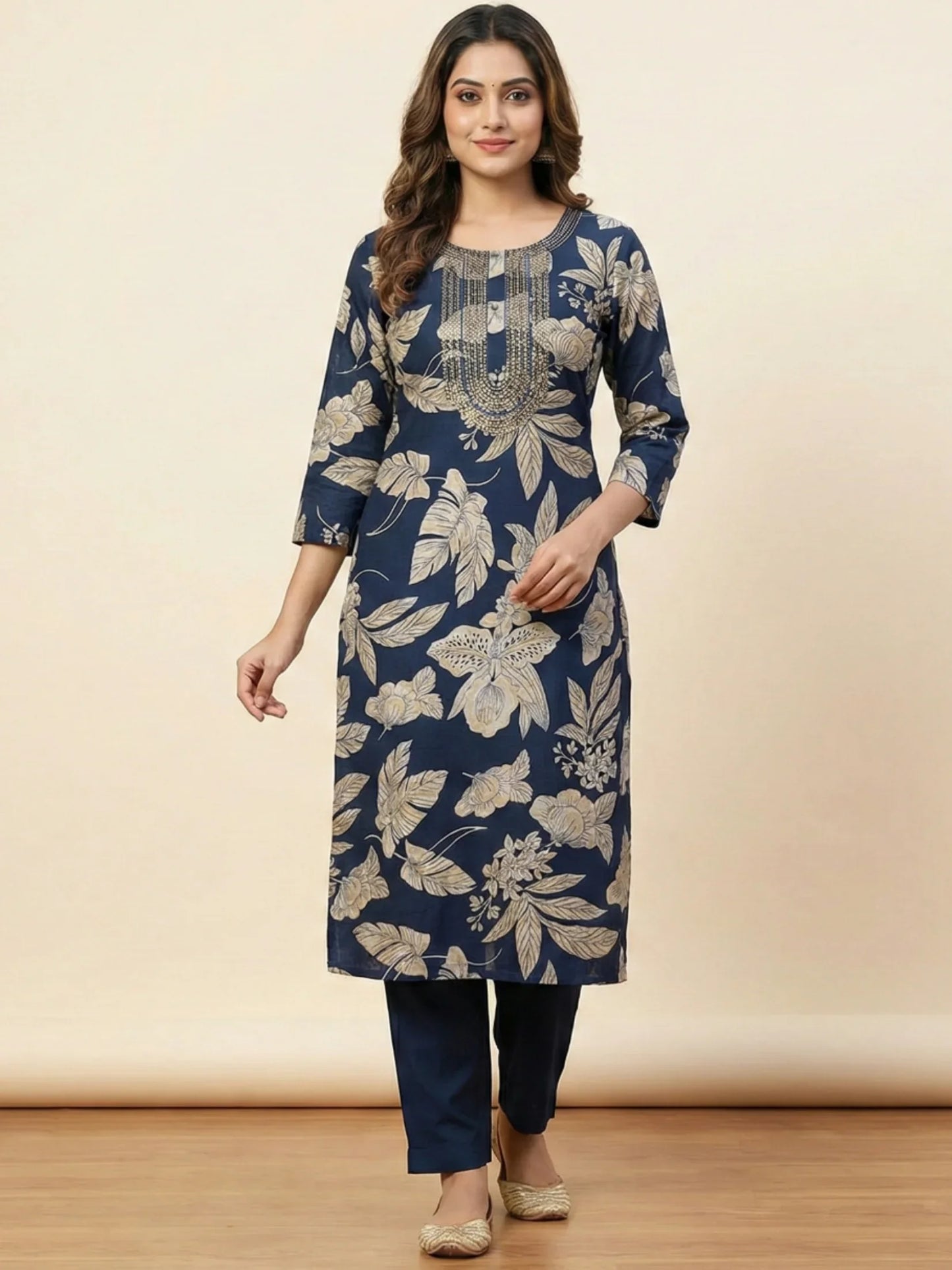 Woman wearing a blue floral kurta with matching pants on a beige background