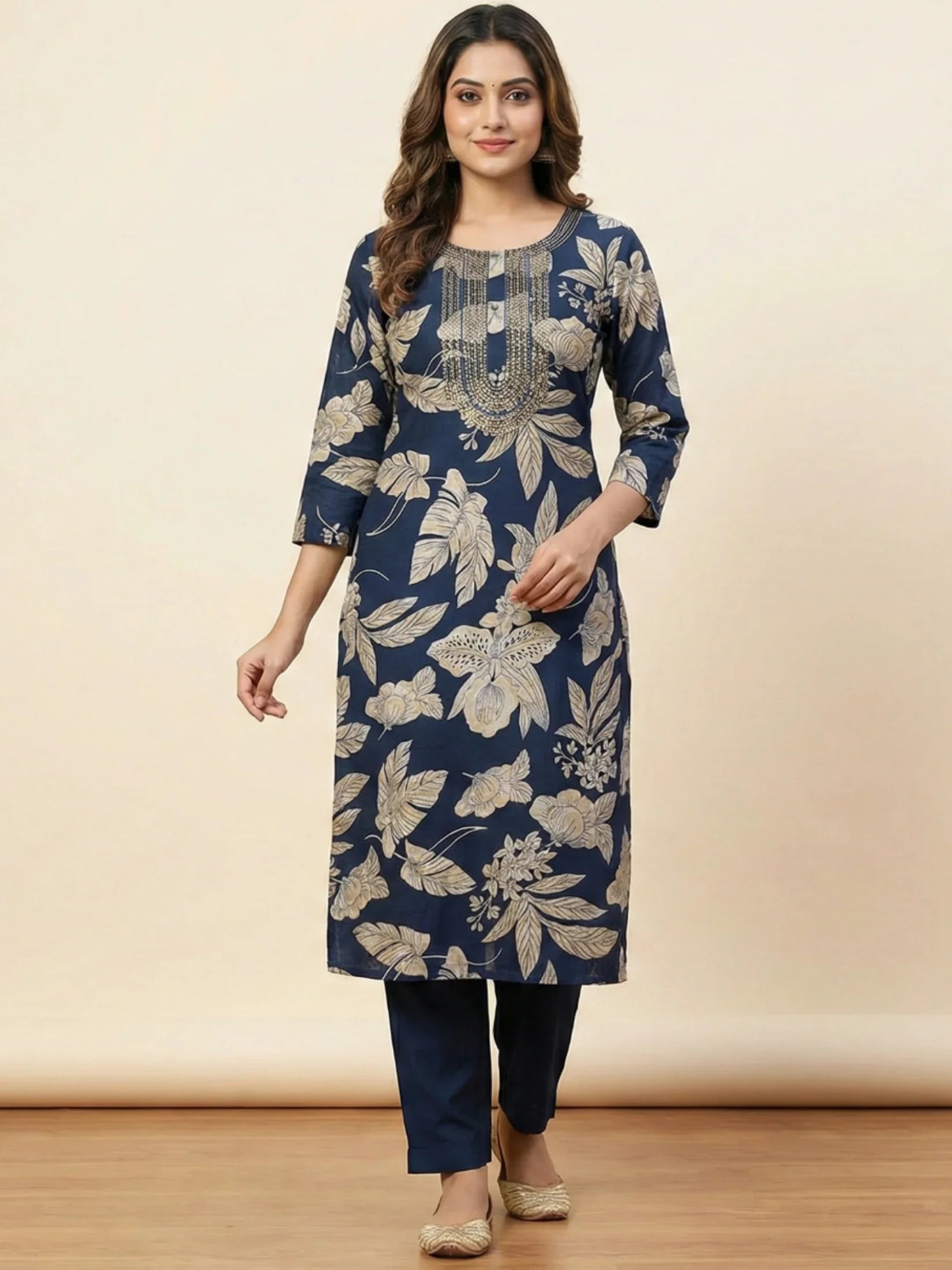 Woman wearing a blue floral kurta with matching pants on a beige background