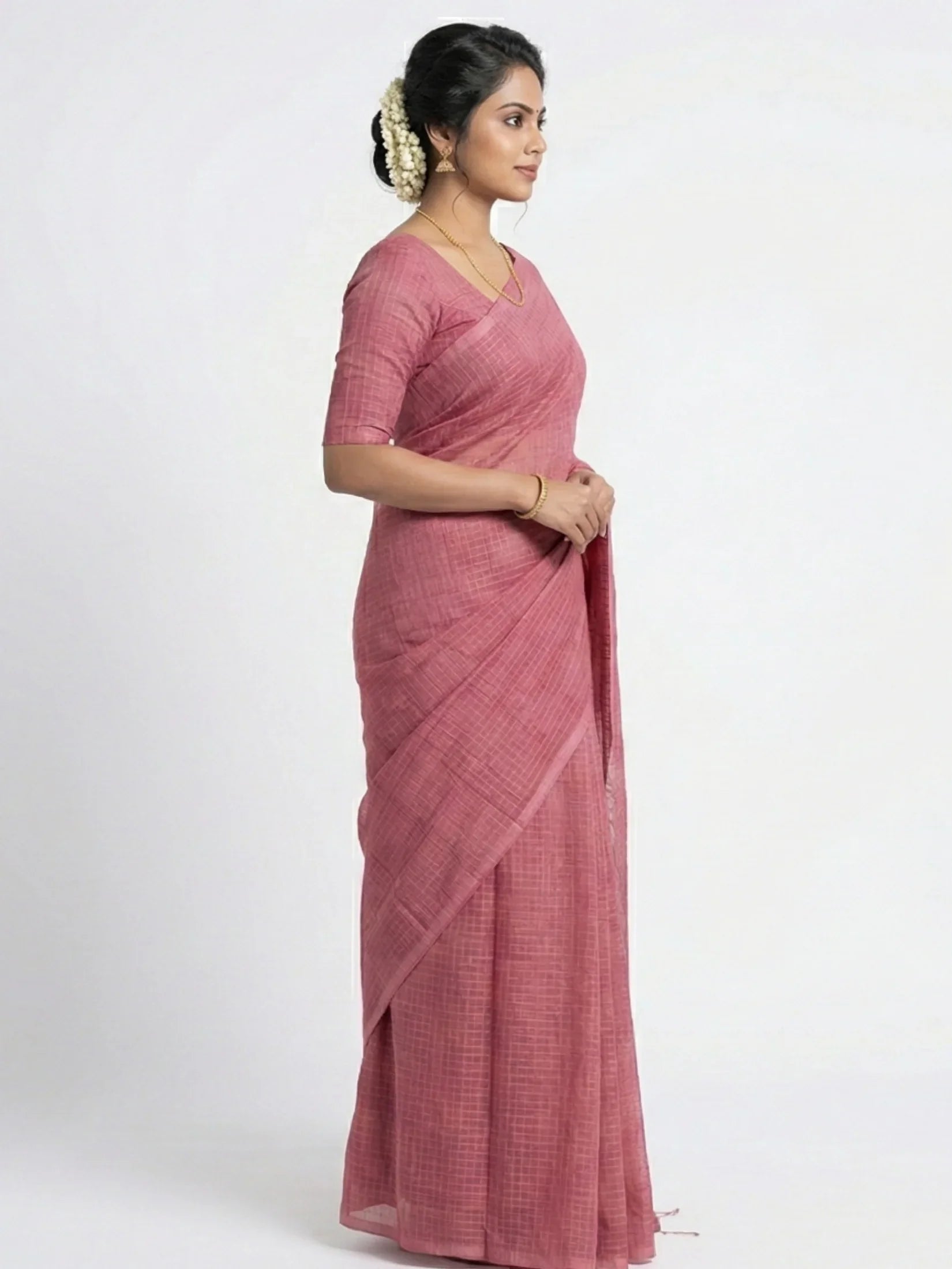 Woman wearing a pink saree on a white background

