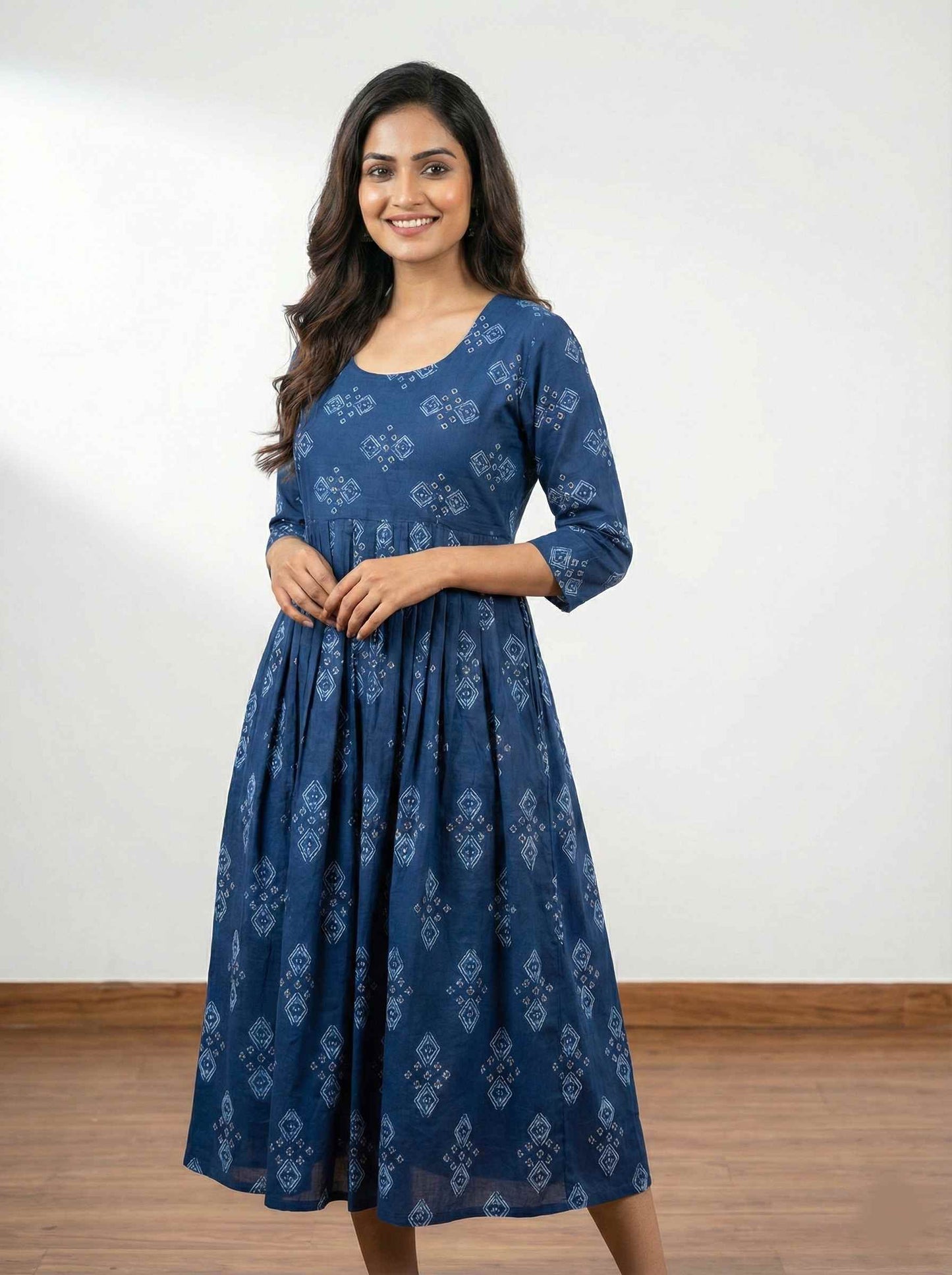 Woman wearing a blue patterned dress against a white background
