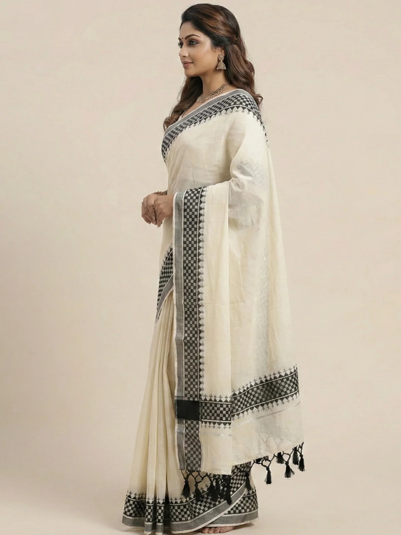 Off-white Kerala cotton set mundu with a woven black and silver checkered border and black tassels.