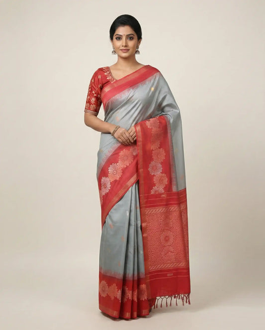 Woman wearing a red and gray saree with a white background
