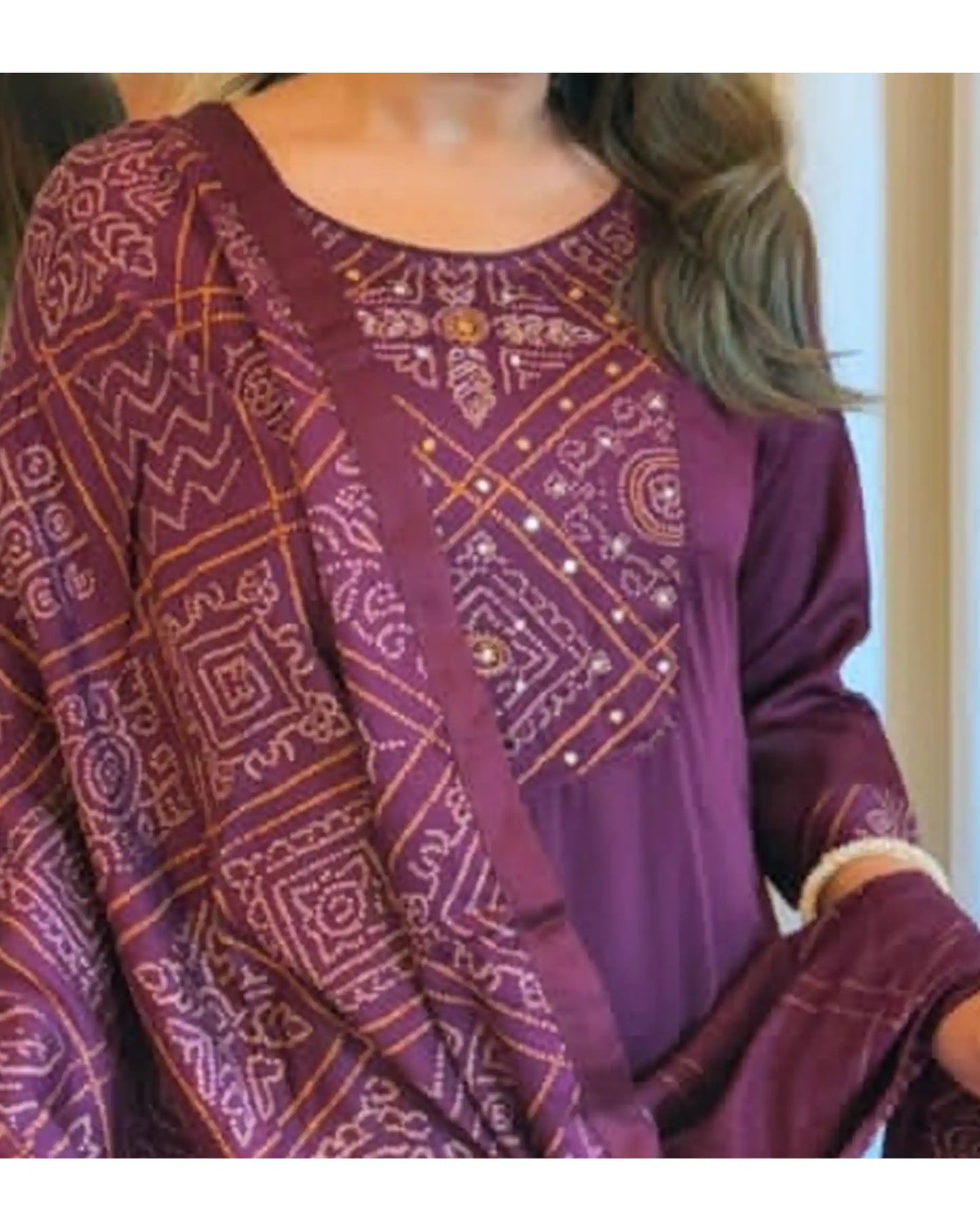Close-up of intricate gold and beige embroidery on the chest of a purple kurti