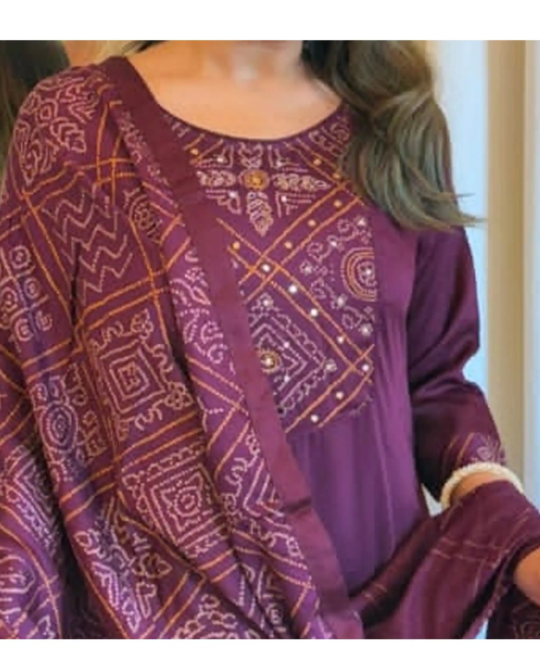Close-up of intricate gold and beige embroidery on the chest of a purple kurti