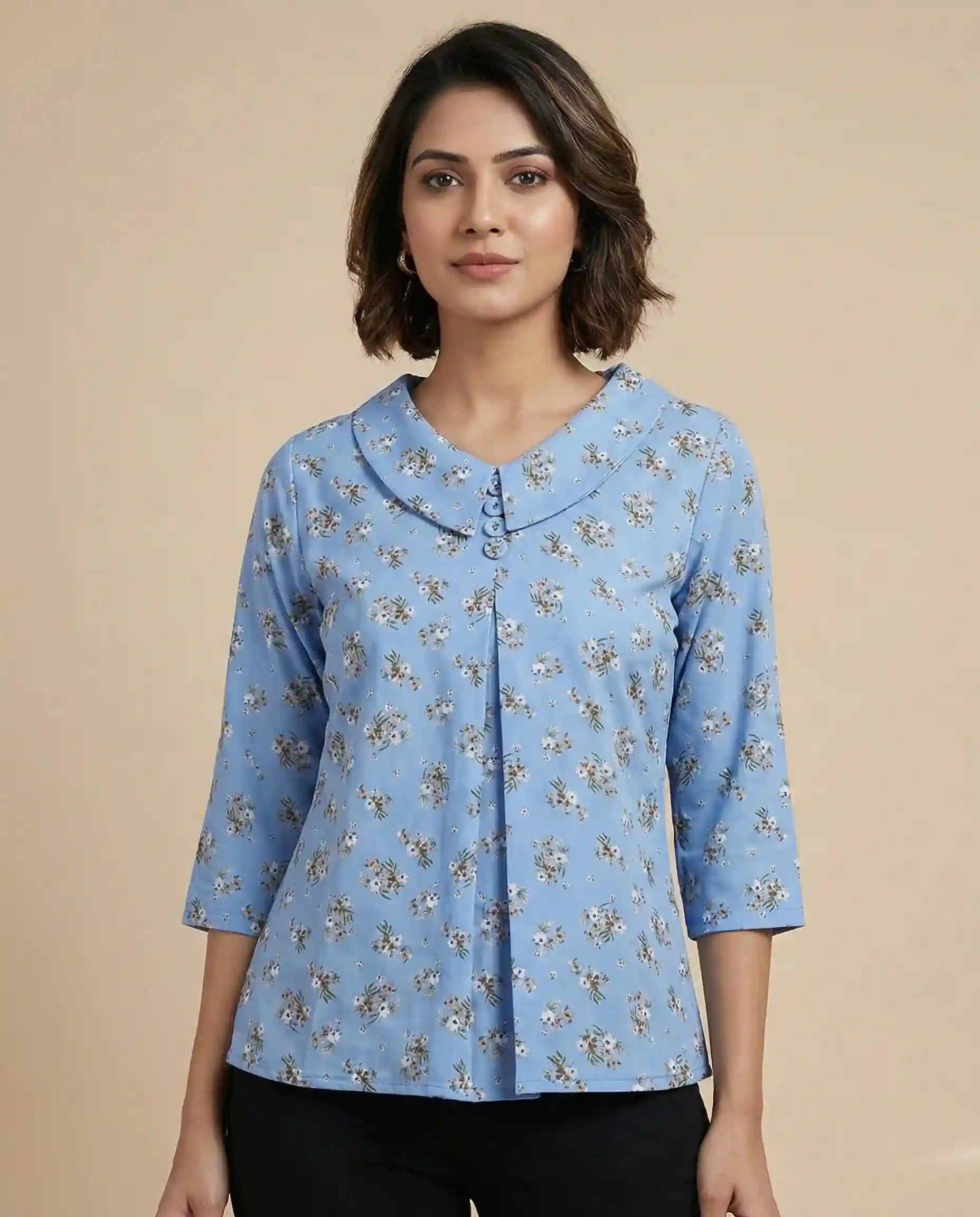 Woman wearing a blue floral blouse against a beige background

