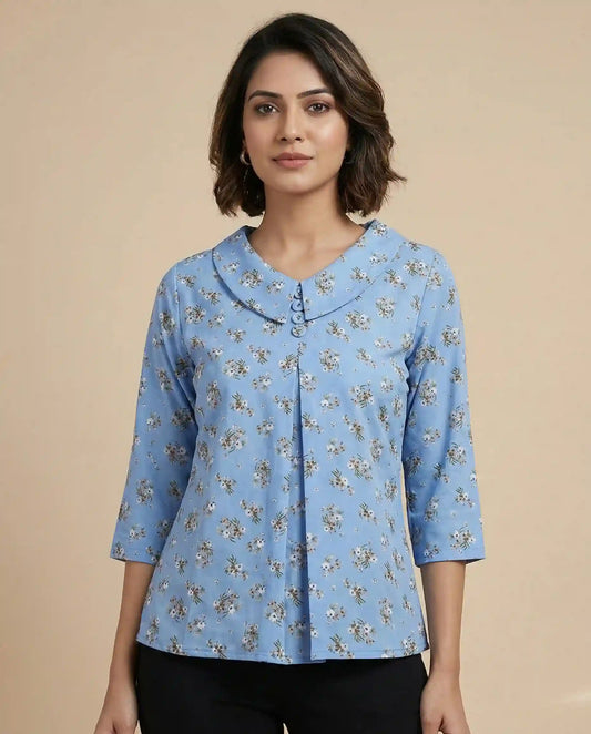 Woman wearing a blue floral blouse against a beige background

