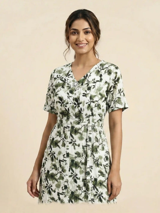 Woman wearing a green floral dress on a beige background

